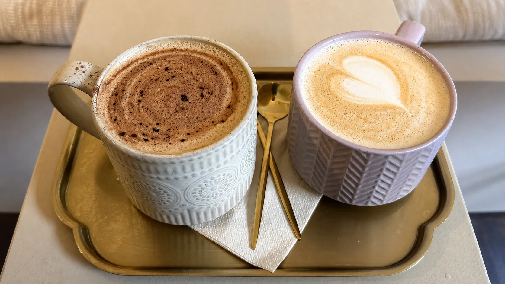 Two coffees served on a gold tray