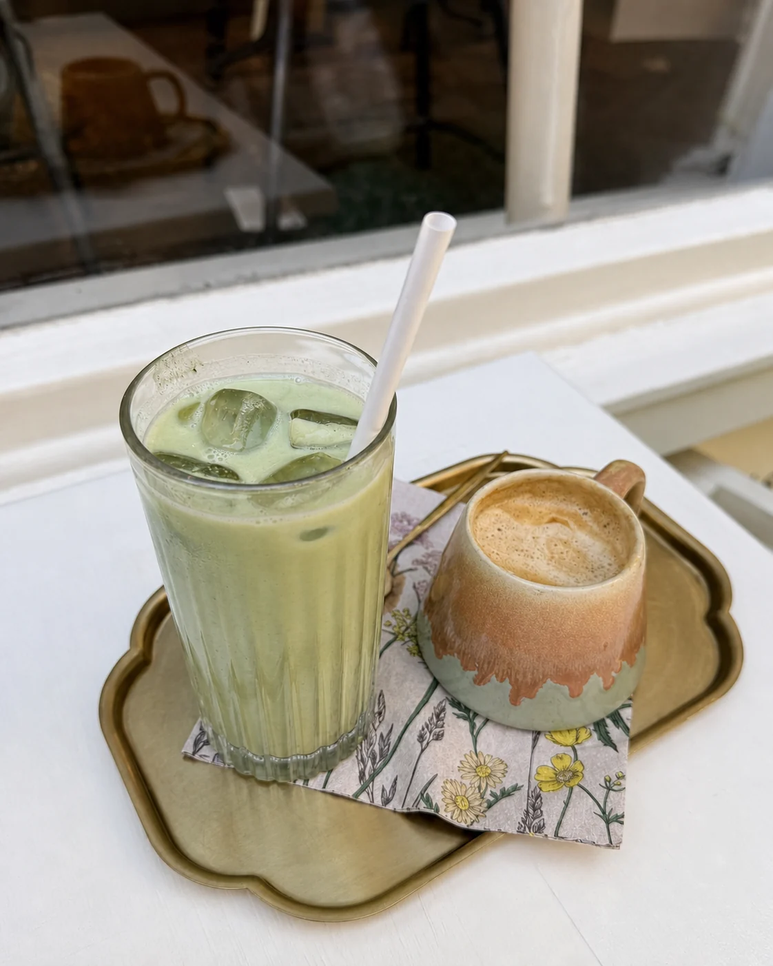 Iced matcha and a coffee served on Sonder's gold tray